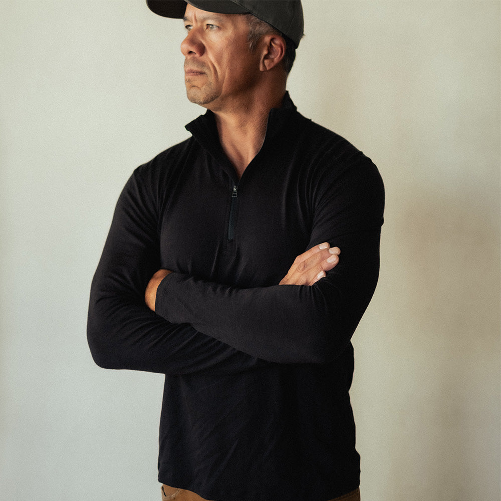 A man wearing a black American made merino wool quarter zip.
