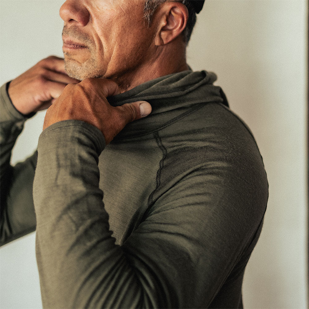 A man wearing a green American made Duckworth merino wool hoody. 